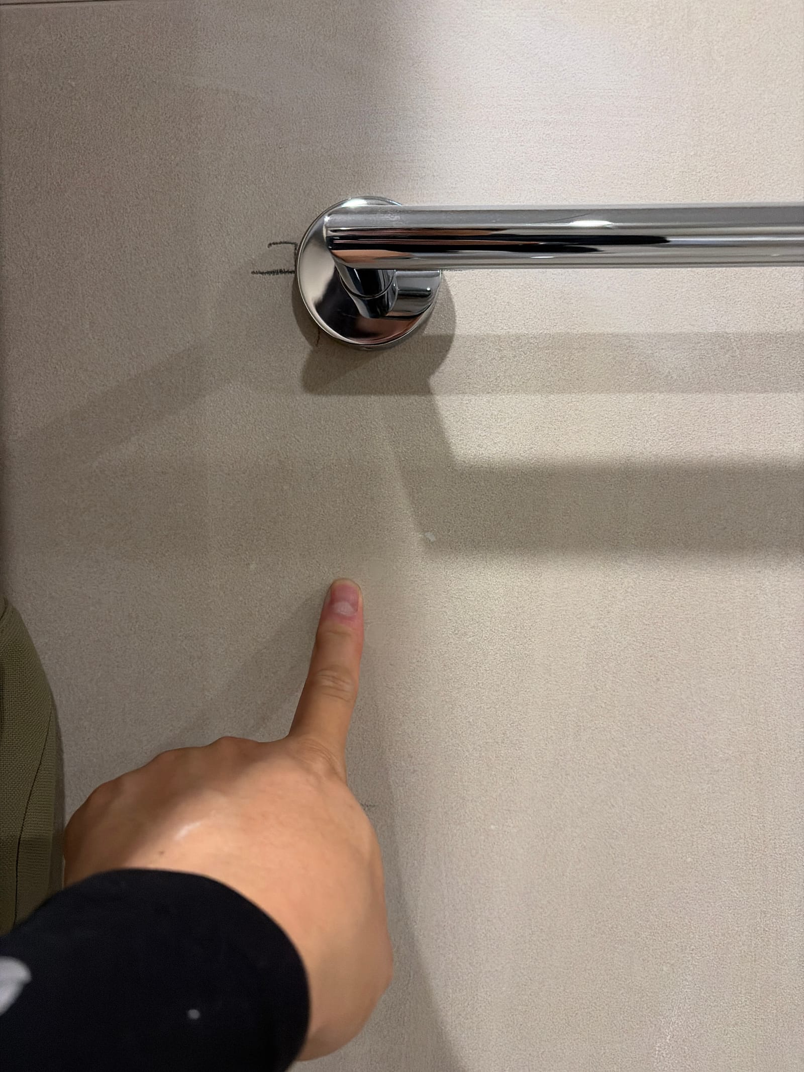 욕실 타일 구멍 메꿈 후 원래 구멍 자리를 가리키는 근접 사진